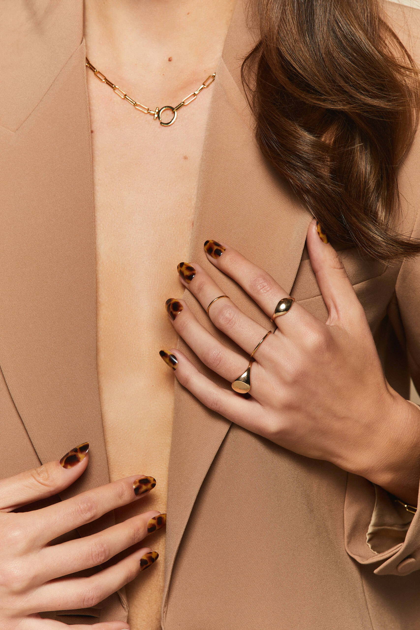 Cat's Meow tortoiseshell pattern press-on nails by Mani Muse, worn by a model (beauty shot).