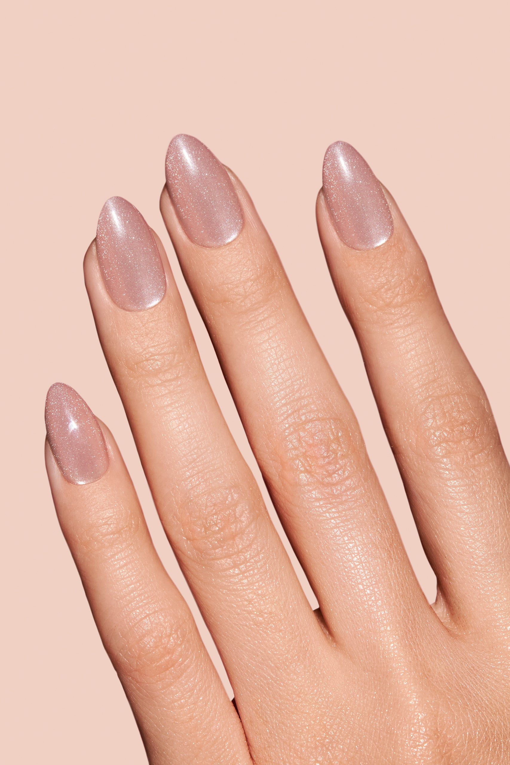 Pinky Blinders rose gold cat-eye press-on nails by Mani Muse, close-up hand shot.