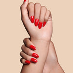 Caught Red Handed red almond press-on nails by Mani Muse, close-up hand shot.