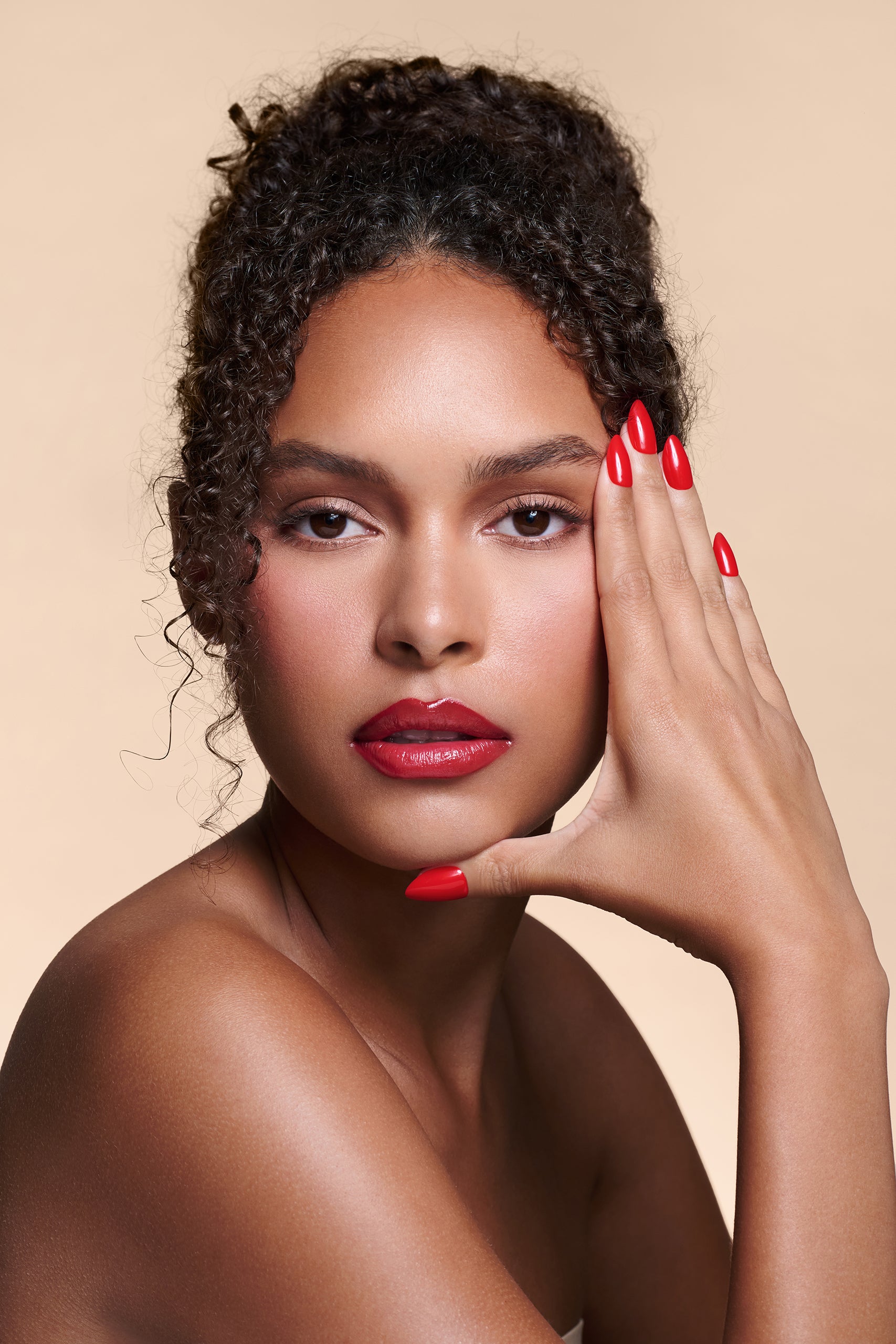 Caught Red Handed red almond press-on nails by Mani Muse, worn by a model (beauty shot).