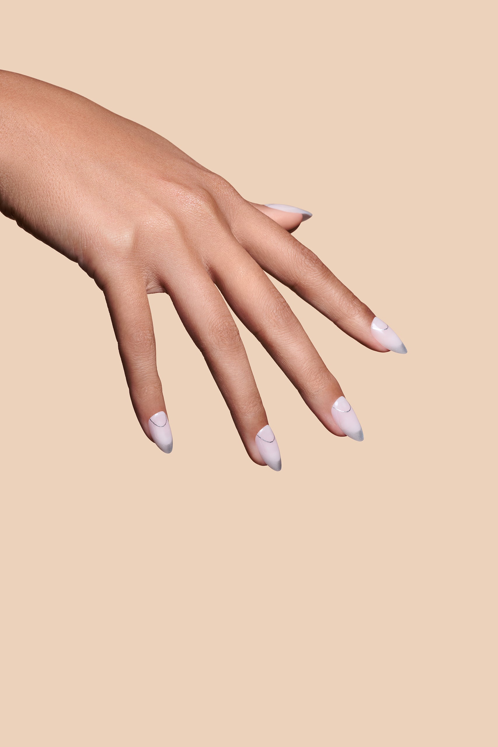 It's The Little Blings silver cat-eye french with chrome press-on nails by Mani Muse, close-up hand shot.