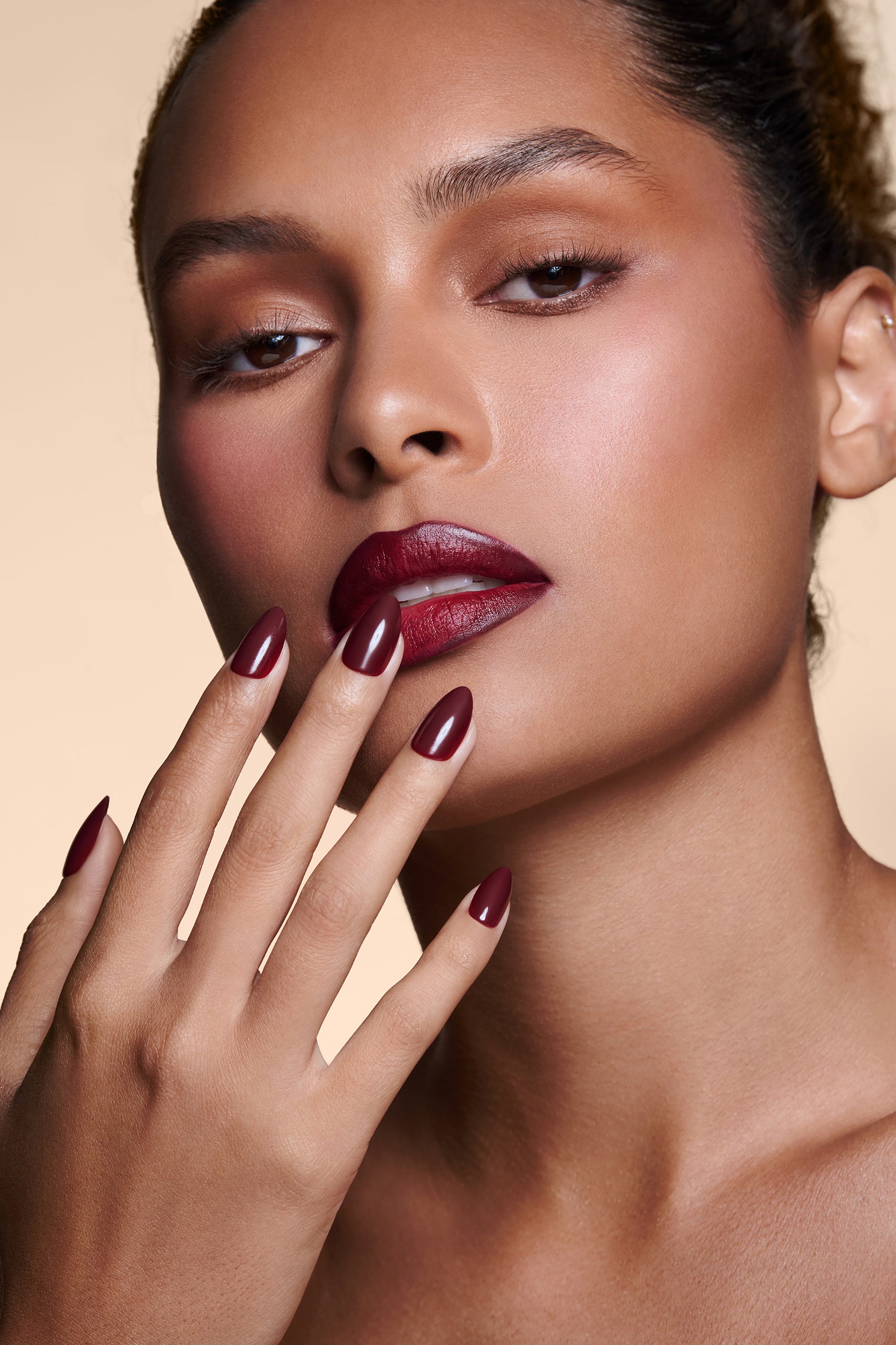 Like a Fine Wino burgundy press-on nails by Mani Muse, close-up on model.