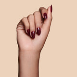 Like a Fine Wino burgundy press-on nails by Mani Muse, close-up hand shot.