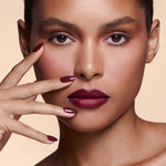 Like a Fine Wino burgundy press-on nails by Mani Muse, worn by a model (beauty shot).