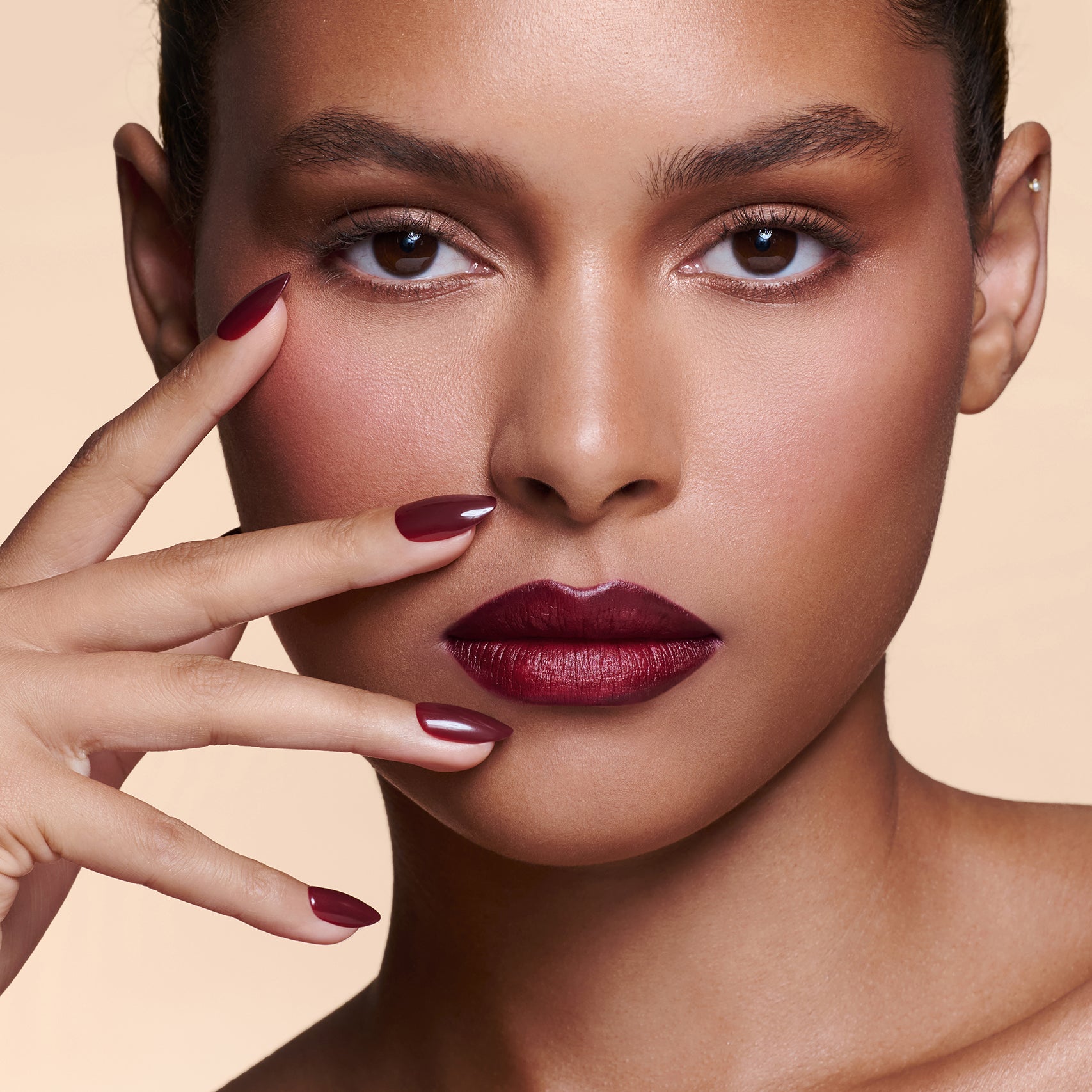 Like a Fine Wino burgundy press-on nails by Mani Muse, worn by a model (beauty shot).