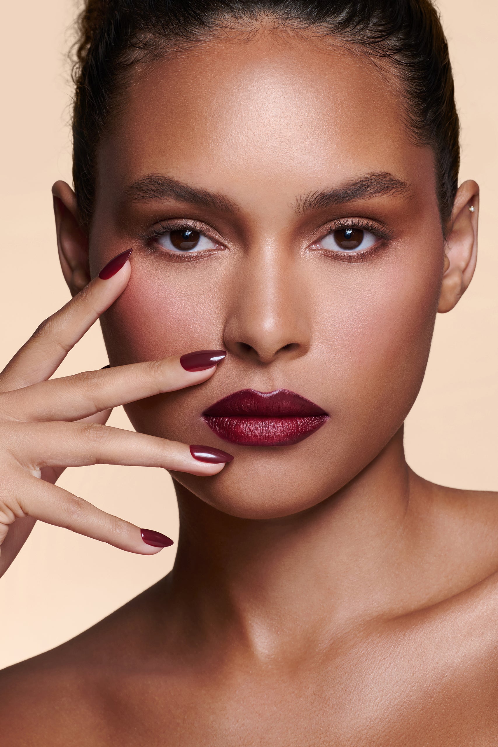 Like a Fine Wino burgundy press-on nails by Mani Muse, worn by a model (beauty shot).