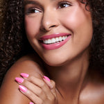 Pink To Make 'Em Wink hot pink glazed press-on nails by Mani Muse, worn by a model (beauty shot).
