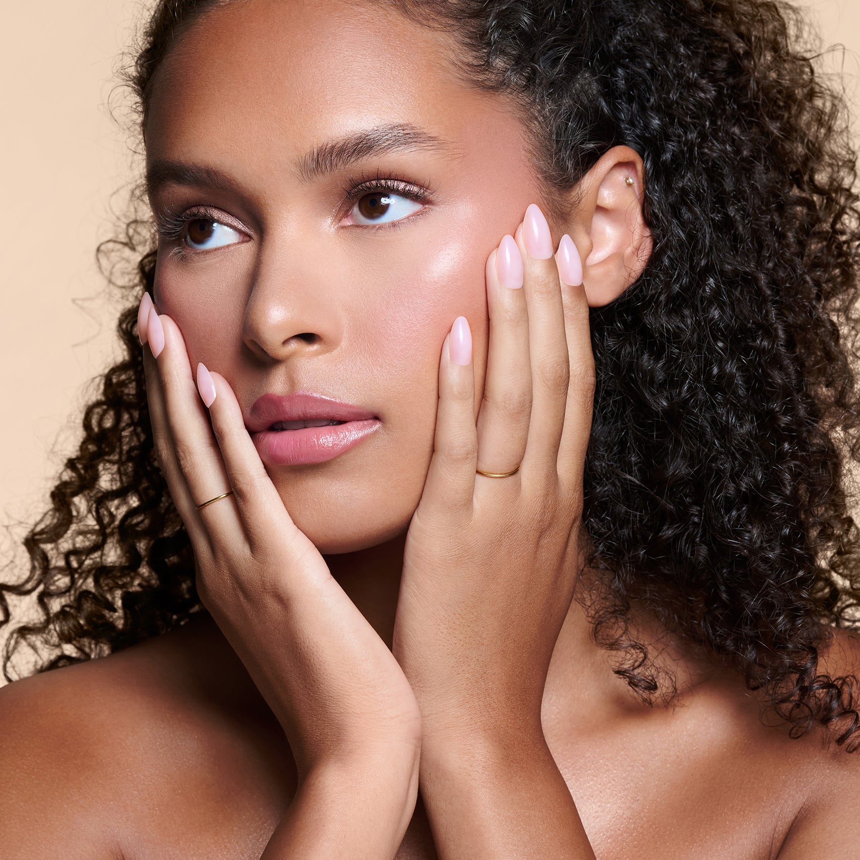 Sheer Thing semi-sheer pink press-on nails by Mani Muse, worn by a model (beauty shot).