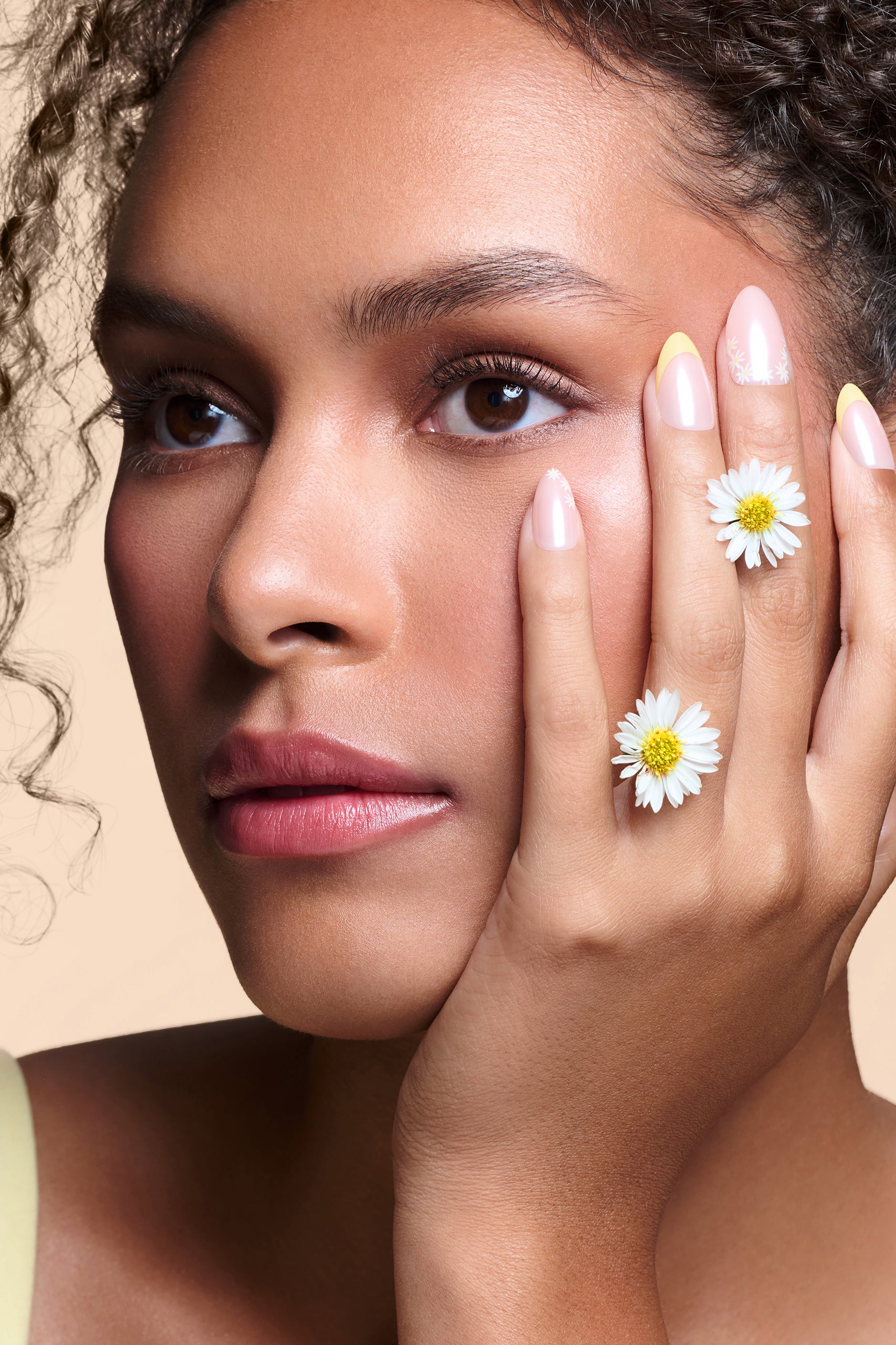 Upsy-Daisy yellow french tips with daisy accents press-on nails by Mani Muse, close-up on model.